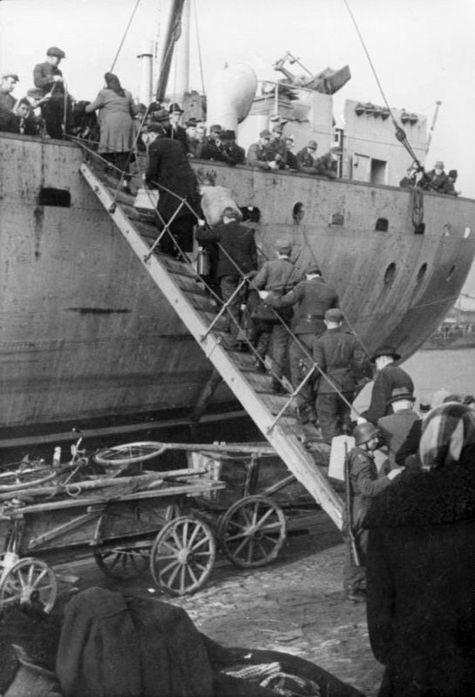 Leidyklos nuotr./Pabėgėliai ir kariai lipa į juos evakuoti turinčius laivus. Kuršas. 1944 m. spalis.