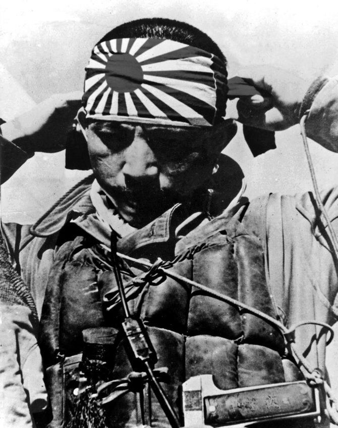 Leidyklos „Briedis“ nuotr./Pilotas kamikadzė rišasi raištį su Japonijos karo vėliava – tekančios saulės piešiniu.