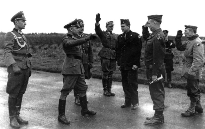 Leidyklos „Briedis“ nuotr./1944 m. liepos 23 d. įprastas kariškas Vermachto pasisveikinimas pridedant ranką prie kepurės pakeistas nacistiniu saliutavimu. Šioje nuotraukoje užfiksuotas vokiečių ir amerikiečių kariškių susitikimas prieš apsikeičiant belaisviais. 1944 m. lapkritis Prancūzija. 