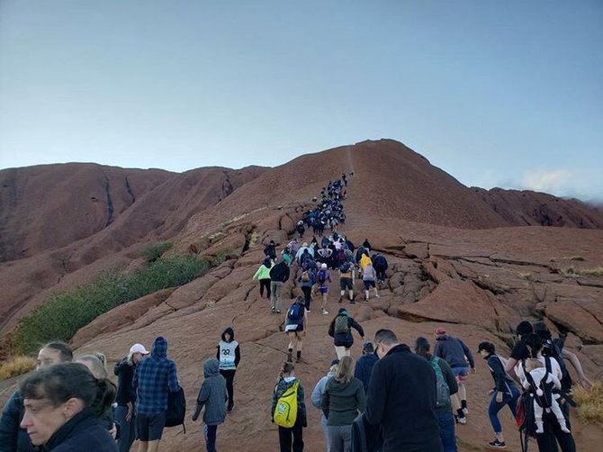 „Reuters“/„Scanpix“ nuotr./Turistai plūsta prie Australijos Uluru kalno paskutiniam kopimui