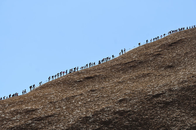 „Reuters“/„Scanpix“ nuotr./Turistai plūsta prie Australijos Uluru kalno paskutiniam kopimui