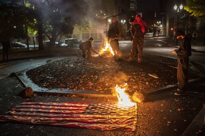 „Scanpix“/AP nuotr./JAV rinkimų naktį Portlande demonstrantai degino Amerikos vėliavas