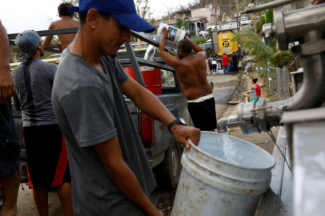 „Reuters“/„Scanpix“ nuotr./Uragano Maria nusiaubto Puerto Riko gyventojai pildo vandens atsargas