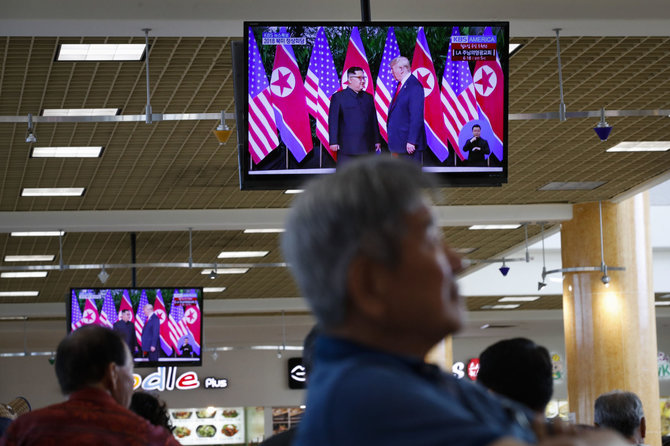 „Scanpix“/AP nuotr./Singapūriečiai stebi Kim Jong Uno ir Donaldo Trumpo susitikimą