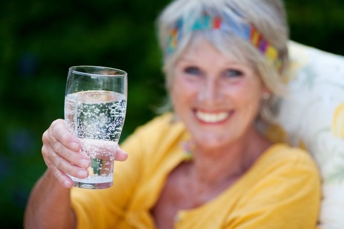 123RF.com nuotr./Moteris geria mineralinį vandenį