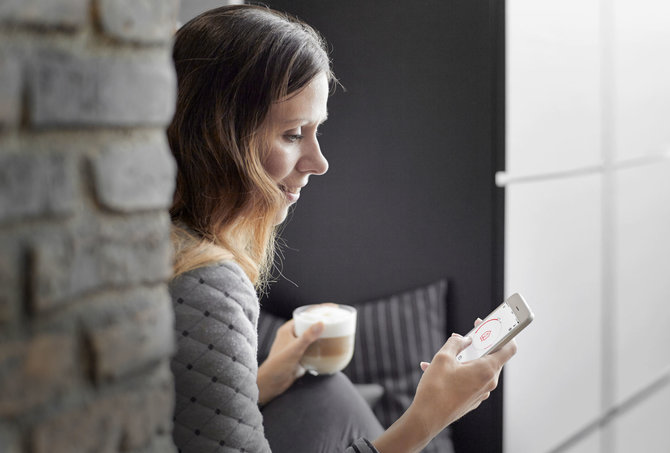 Bendrovės „Danfoss“ nuotr./Moteris naudojasi išmaniąja šildymo sistema „Danfoss Link“ 