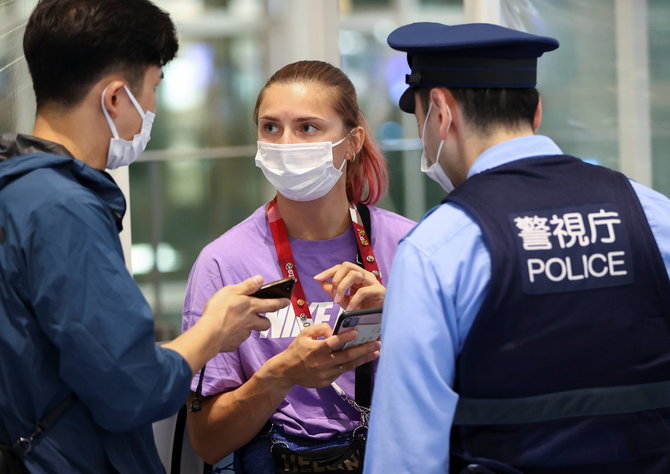 „Scanpix“ nuotr./Kristina Cimanouskaja yra lydima pareigūnų Tokijo „Haneda“ oro uoste