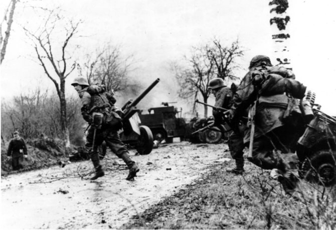 Knygos leidėjų nuotr./Vokiečių puolimas Ardėnuose. Antrajame plane – sudaužyta amerikiečių karinė technika. 1944 m. gruodis.