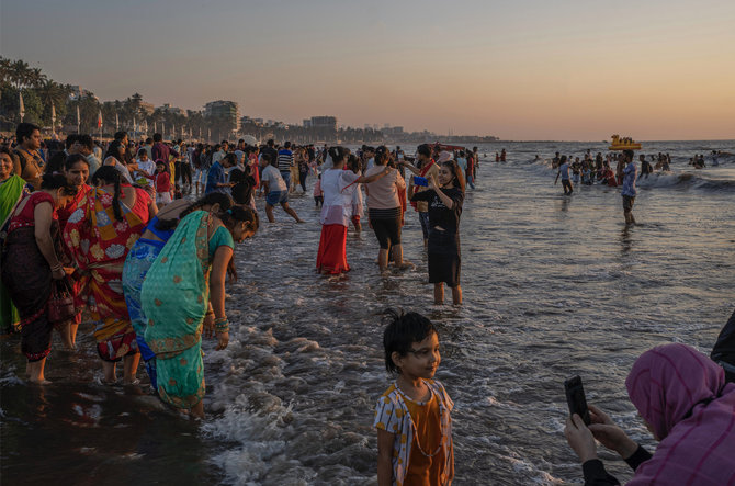 „Scanpix“/AP nuotr./Indijos žmonės prie Arabijos jūros pasitinka saulėlydį