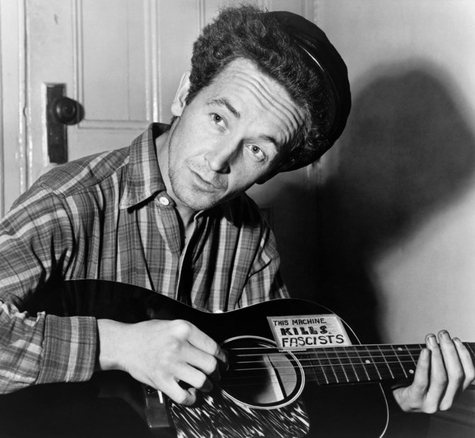 Al Aumuller nuotr./New York World-Telegram and the Sun nuotr./ Wikipedia.org nuotr./Woodie Guthrie su savo gitara, ant kurios užrašyta „Ši mašina žudo fašistus“, 1943-iųjų kovas