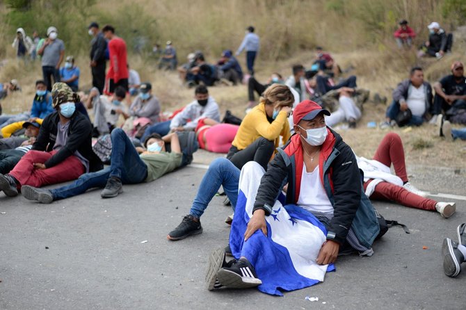 AFP/„Scanpix“ nuotr./Migrantai iš Hondūro, bandantys patekti į Gvatemalą, kad pasiektų JAV