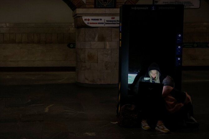 Žmonės slėpiasi metro stotyje per Rusijos karinę ataką Kyive.