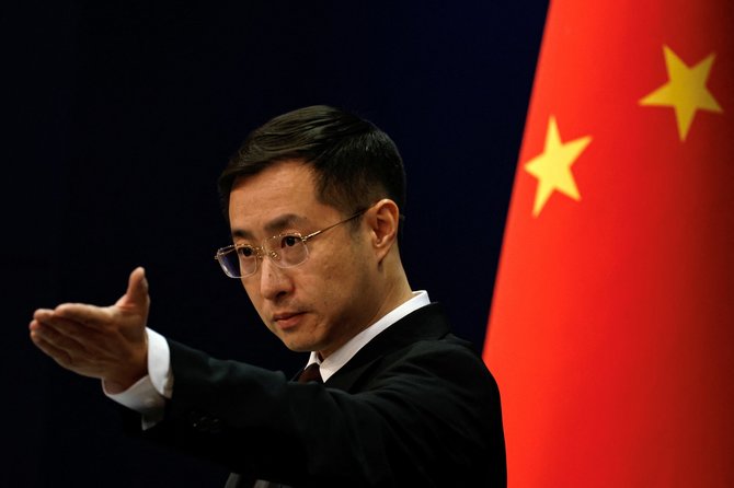 Kinijos Užsienio reikalų ministerijos atstovas gestikuliuoja Pekino spaudos konferencijoje. / Tingshu Wang / REUTERS