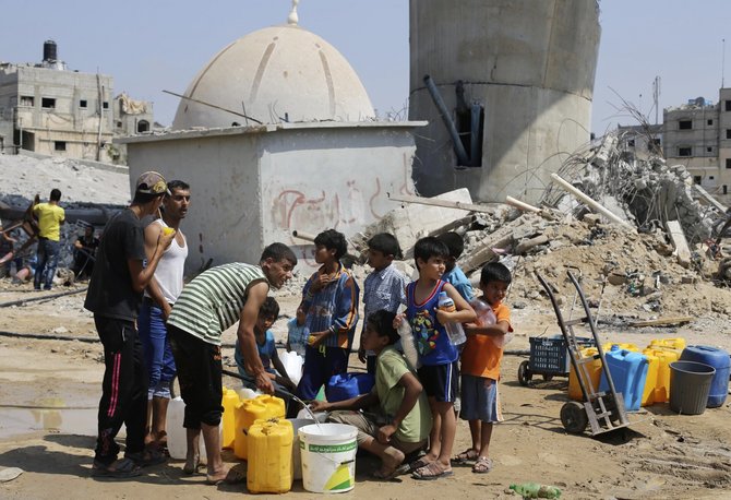 Palestiniečių vaikai renka vandenį per penkių dienų paliaubas Gazos juostoje. / Ibraheem Abu Mustafa / REUTERS