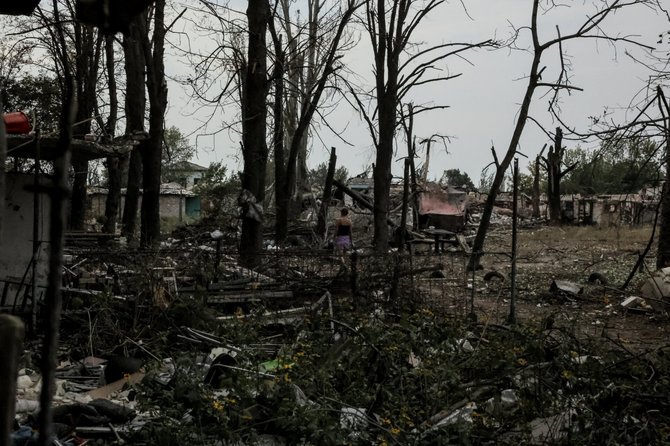 Vietinis gyventojas vaikščioja prie smarkiai pažeistų namų. / UKRAINIAN ARMED FORCES / via REUTERS