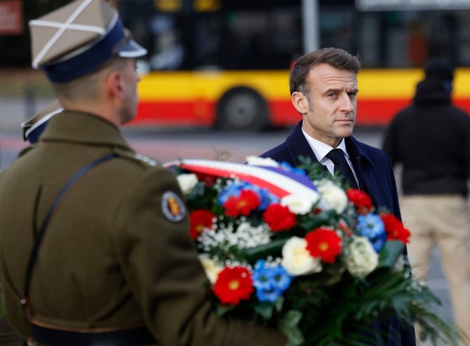 Emmanuelis Macronas lankosi prie Šarlio de Golio skulptūros Varšuvoje / WOJTEK RADWANSKI / AFP