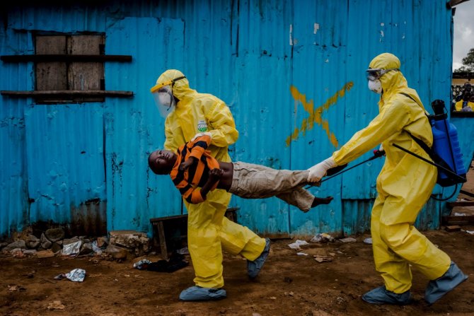 „Reuters“/„Scanpix“ nuotr./Balandžio 20 diena. Darbinikai neša berniuką, kuris kaip įtariama, užsikrėtęs ebola, į gydymo centrą Liberijoje