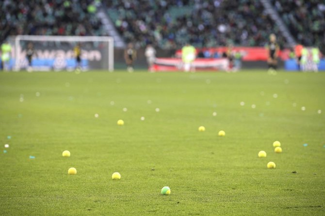 „Scanpix“ nuotr./Vokietijos futbolo sirgaliai protestuodami mėto į aikštę teniso kamuoliukus