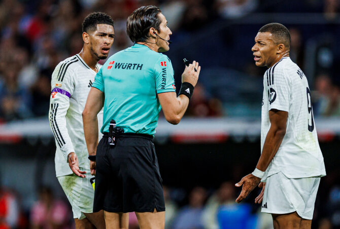 Vida Press nuotr./Futbolo teisėjas Jose Luisas Munuera Montero Madrido „Real“ žvaigždžių Jude'o Bellinghamo ir Kyliano Mbappe apsuptyje