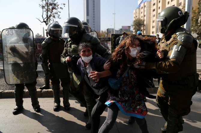 „Reuters“/„Scanpix“ nuotr./Policija sulaiko protestuotojus Santjage.