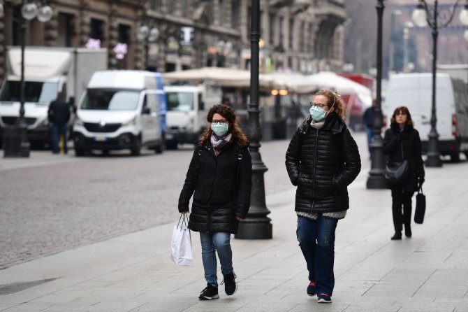 AFP/„Scanpix“ nuotr./Žmonės su kaukėmis gatvėse