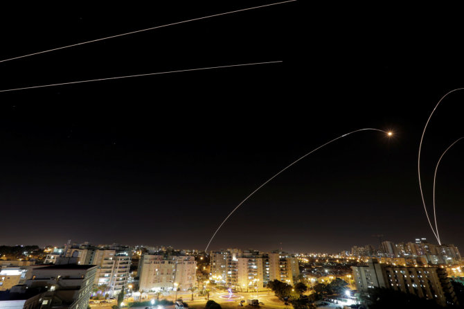 „Reuters“/„Scanpix“ nuotr./Izraelio oro gynybos raketų pėdsakai nakties danguje virš Aškelono miesto
