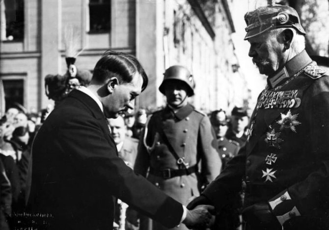 Vokietijos Bundesarchyvo/Wikimedia.org nuotr./Reichskancleriu paskirtas Adolfas Hitleris pagarbiai sveikinasi su reichsprezidentu Pauliumi von Hindenburgu (1933 m. kovo 21 d.)