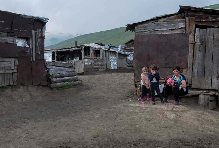 Gabrielės Navickaitės / 15min nuotr./Giorgi žmona ir vaikai sėdi prie ant suoliuko prie savo namų Kaukazo kalnuose, 2022 m. liepos 31 d. 