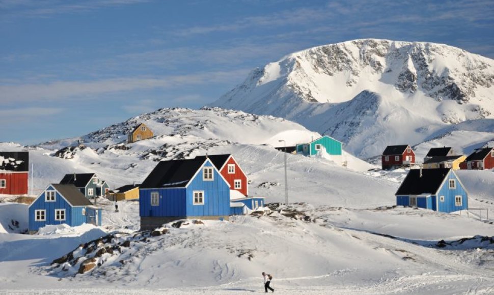 Tipiškas Grenlandijos vaizdas - baltame sniege boluojantys spalvingi mediniai namukai 