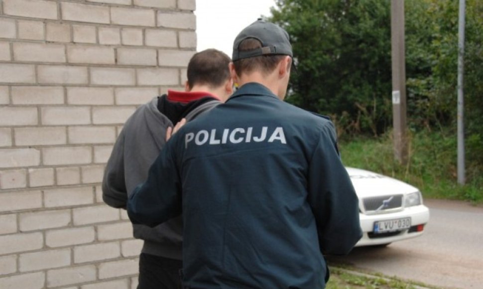 Policininkas veda sulaikytąjį