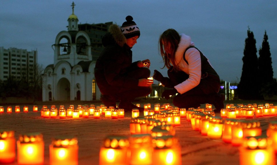 Žmonės dega žvakes netoli stačiatikių bažnyčios Minske