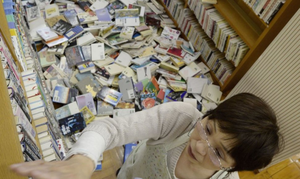 Po žemės drebėjimo Japonijoje bibliotekos darbuotoja deda knygas atgal į lentynas