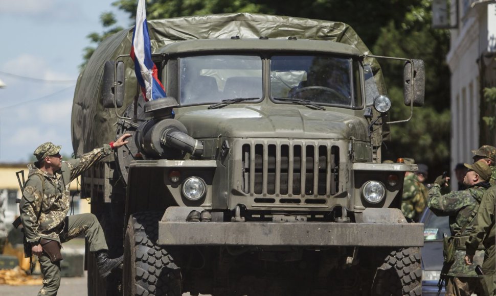 Prorusiški teroristai prie karinio sunkvežimio su Rusijos vėliava.