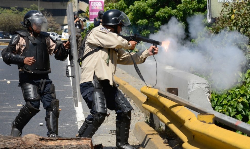 Venesuelos nacionalinės gvardijos kariai šaudo ašarines dujas į protestuotojus Karakase