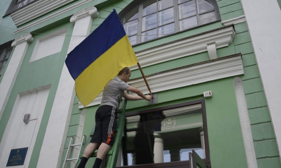 Ukrainos vėliava kabinama prie balsavimo apylinkės Dobropilyje, Donecko srityje