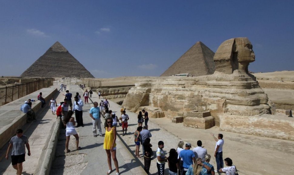Turistai fotografuojasi prie Sfinkso ir Gizos piramidžių.