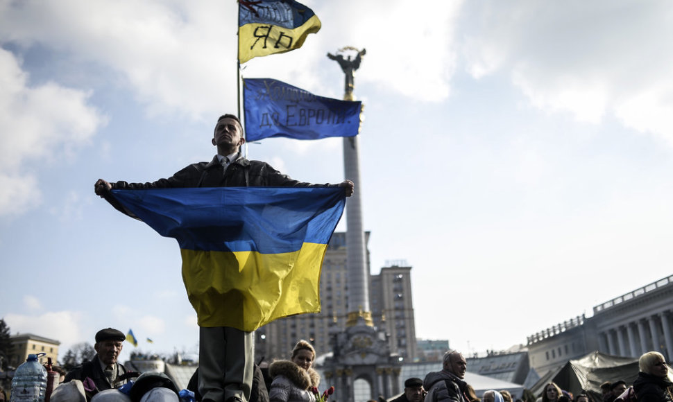 A man holds a Ukrainian flag as he stands on Kiev's Independence Square on February 24, 2014. Ukraine issued an arrest warrant Monday for ousted president Viktor Yanukovych over the "mass murder" of protesters and appealed for $35 billion in Western aid to pull the crisis-hit country from the brink 