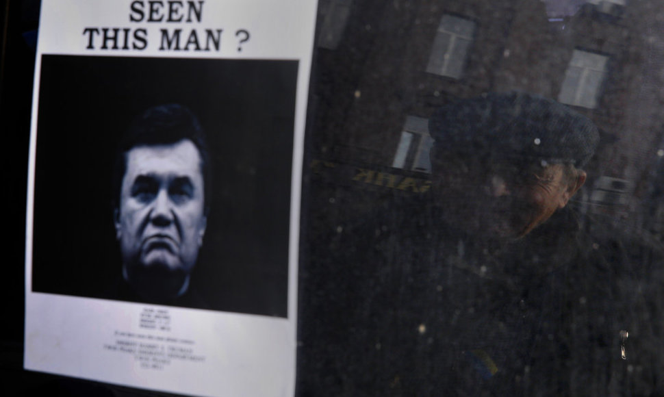 A elderly man looks at a "Wanted" notice for fugitive Ukrainian President Victor Yanukovich, plastered on the window of a car used as barricade near Kiev's Independent Square February 24, 2014. Ukrainian President Viktor Yanukovich, ousted after bloody street protests in which demonstrators were sho