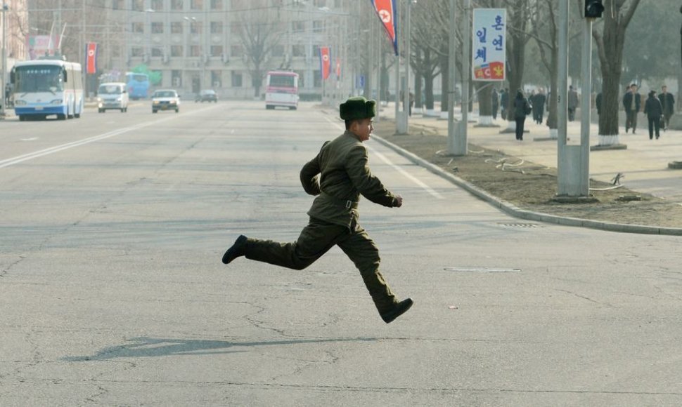 Šiaurės Korėjos karys bėga per gatvę.