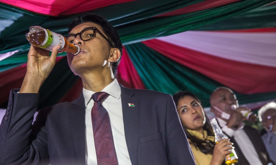 Madagaskaro prezidentas Andry's Rajoelina žurnalistams demonstruoja geriantis tariamą vaistą nuo COVID-19 „Covid Organics“ 