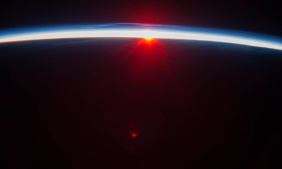 Šioje NASA nuotraukoje užfiksuotas saulėlydis virš Aleutų salų ir regima tankioji atmosferos sluoksnio dalis