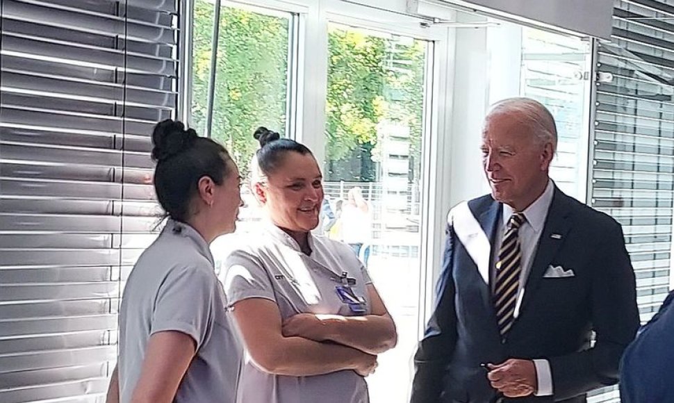 JAV prezidentas J.Bidenas pats priėjo prie „City Service Cleaning“ darbuotojų, jas užkalbino bei pasiūlė kartu nusifotografuoti