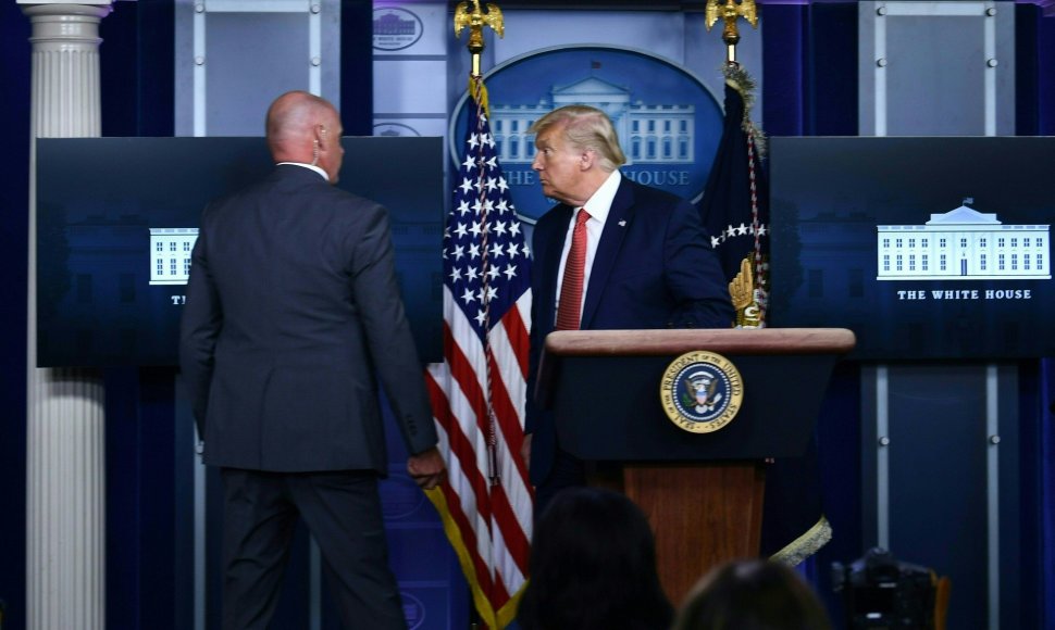Donaldas Trumpas išvedamas iš Baltųjų Rūmų konferencijų salės