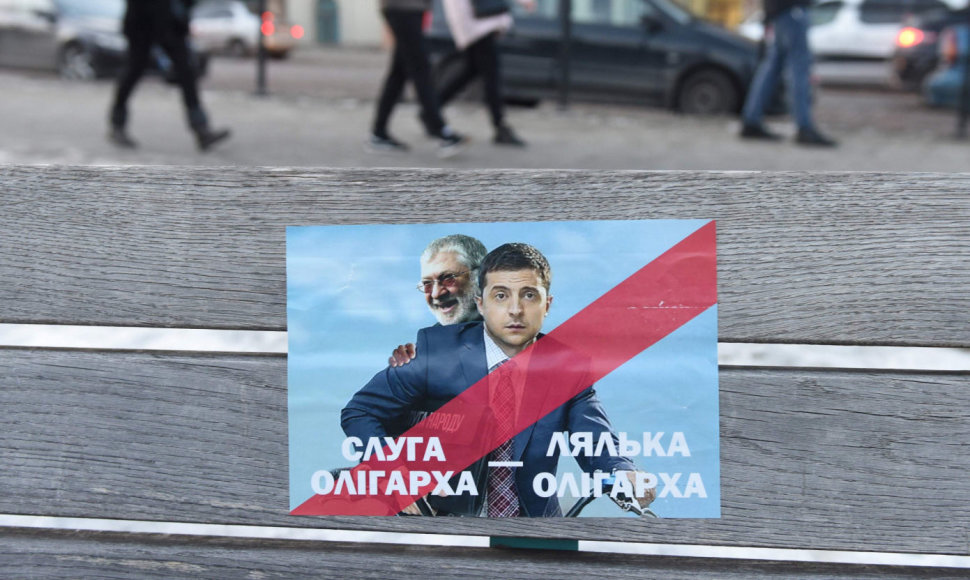 Plakatas su užrašu „Oligarcho tarnas“. Ant jo – Ihoris Kolomoiskis ir Volodymyras Zelenskis