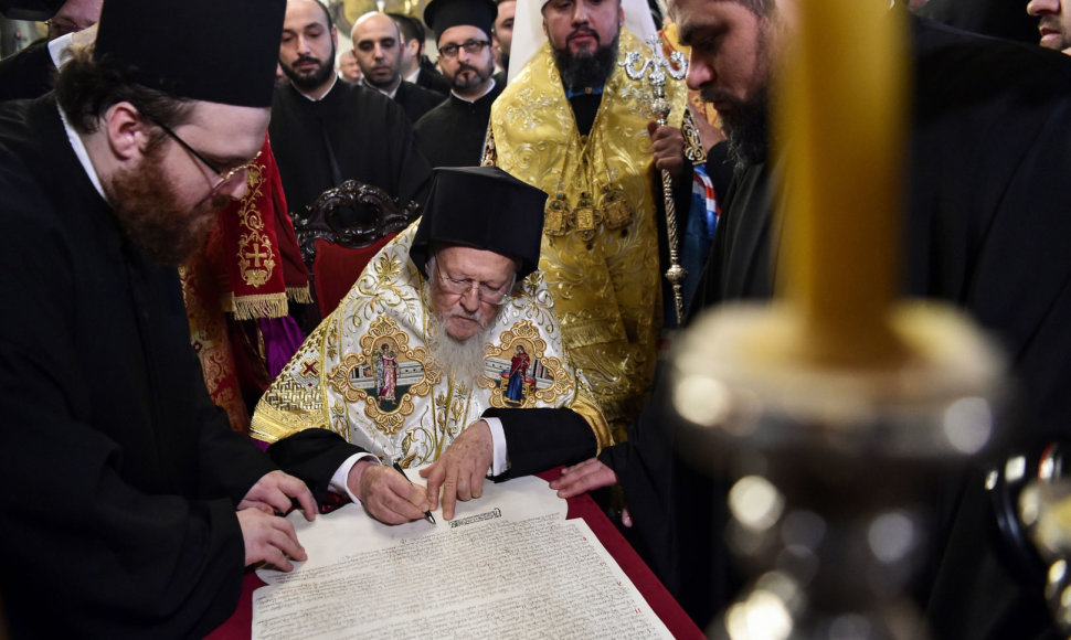 Konstantinopolio ekumeninis patriarchas Baltramiejus I pasirašo tomosą.