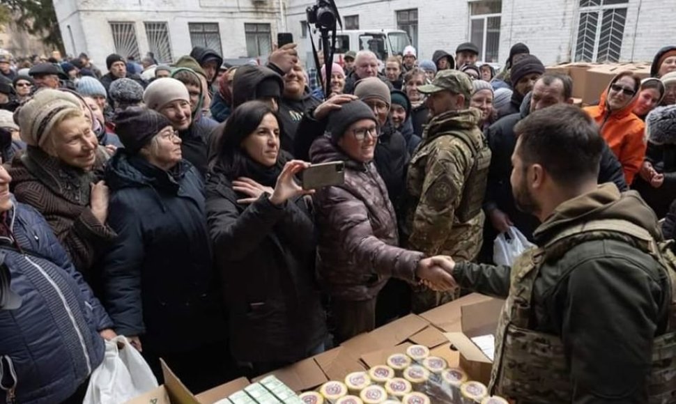 Nuotraukoje, kurioje įamžintas išlaisvintos Bučos gyventojus aplankęs V.Zelenskis, matoma maisto parama iš Lietuvos.
