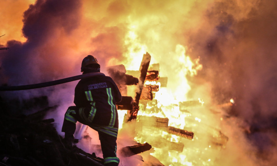 Ugniagesys gelbėtojas kovoja su ugnimi