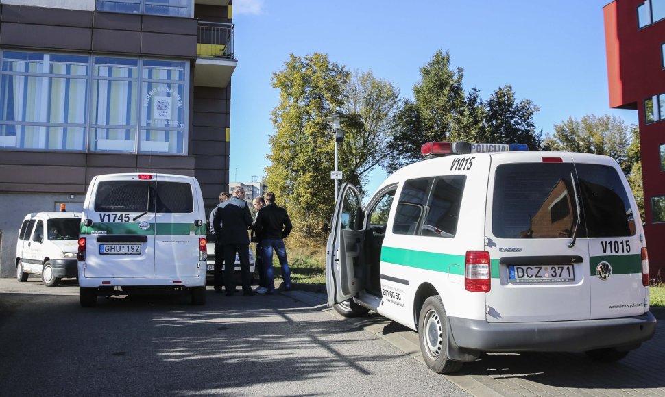 Prie LNK pastato mašinoje sėdintis žmogus