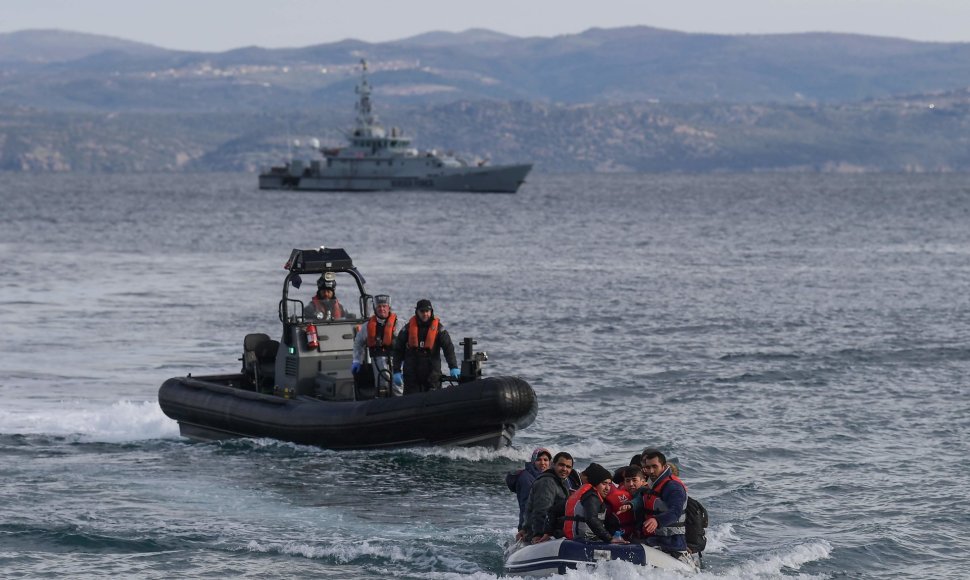 Graikijos pakrantės apsaugos laivai prie valties su migrantais