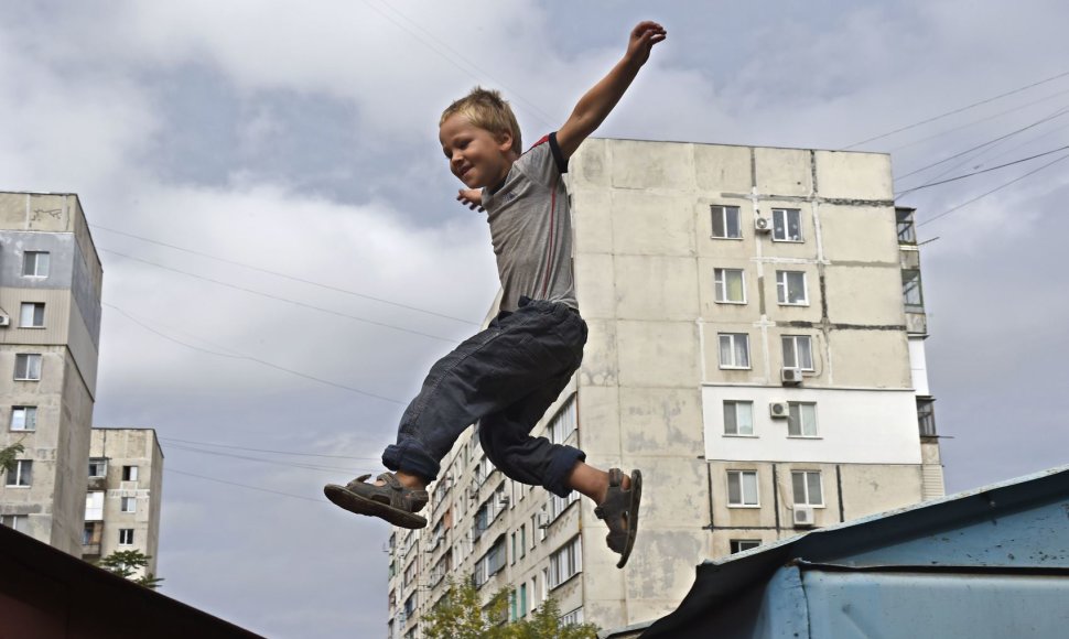 Mariupolyje berniukas šokinėja ant metalinių garažų stogų